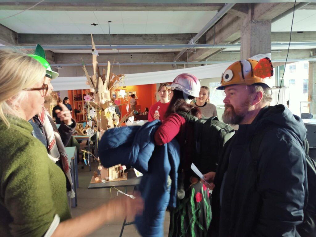 Photo of Sarah Lynne Bowman and Kjell Hedgard Hugaas in helmets talking to people