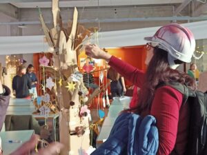 Photo of Sarah Lynne Bowman in a helmet putting an ornament on a tree